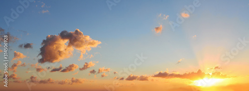 Blue sky clouds background. Beautiful landscape with clouds and orange sun on sky © millaf