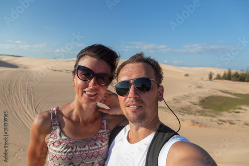 Vietnam, near the city of Mui Ne, entertainment of local people, selfie of a young couple in the desert © evgenii