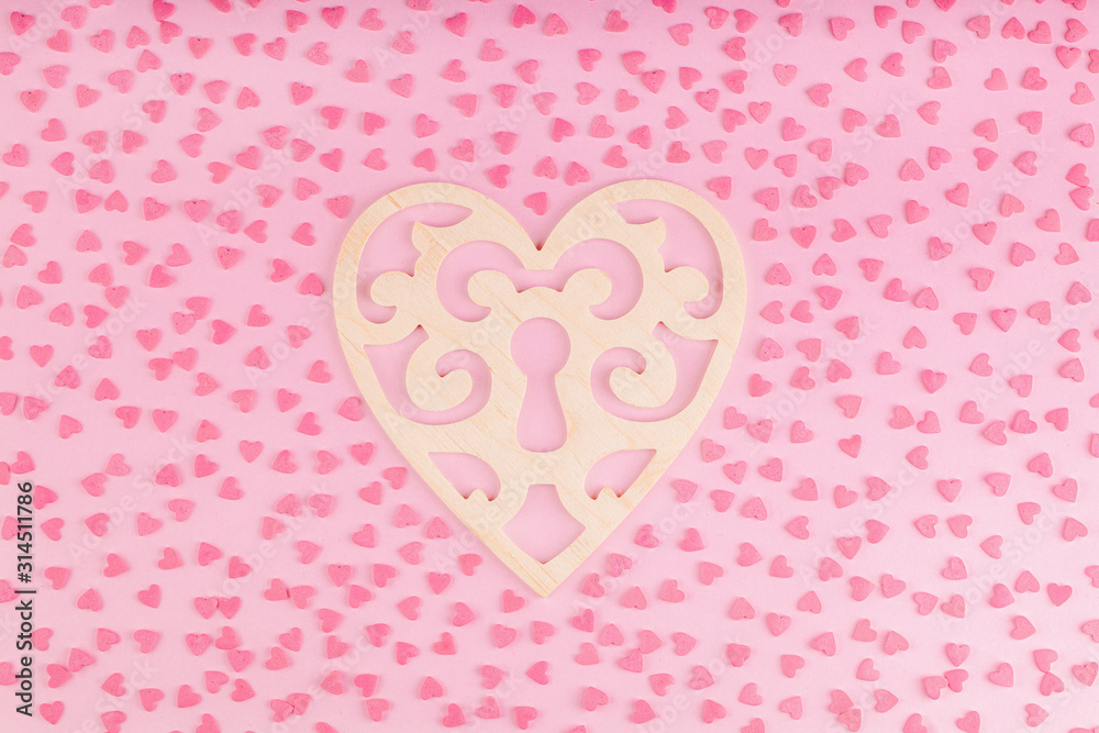 Wooden Ornament Heart Shaped Decoration with Small Hearts on a Pink Background. Concept of Valentines Day Celebration 