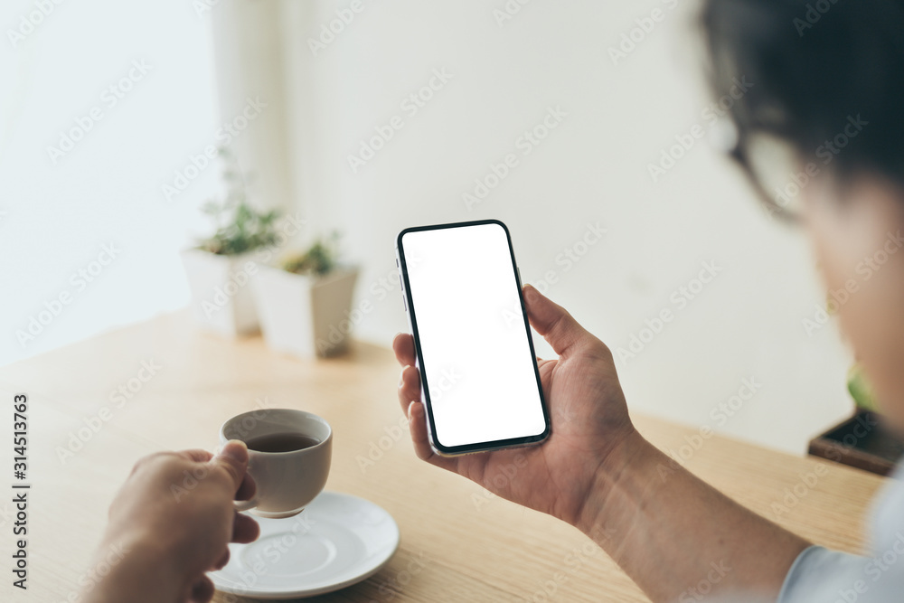 Mockup image blank white screen cell phone.man hand holding texting using mobile on desk at office.background empty space for advertise text.people contact marketing business,technology Mockup image blank white screen cell phone.man hand holding texting using mobile on desk at office.background empty space for advertise text.people contact marketing business,technology