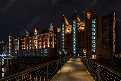 Illuminated famous historic buildings in the Speicherstadt (warehouse district) Hamburg after sunset at night