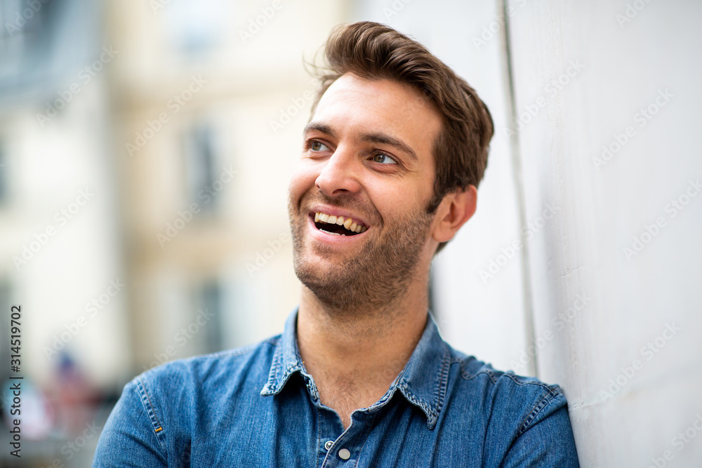 Close up older man leaning against wall and smiling while looking away Close up older man leaning against wall and smiling while looking away