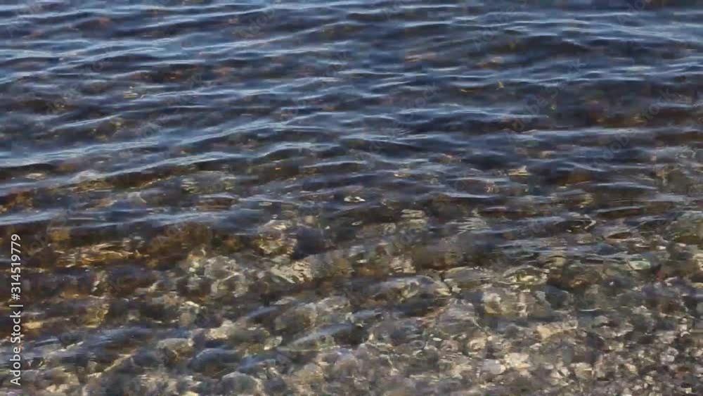 Movement of the transparent and clean water of Lake Garda. Close-up. Staycations concept of tourism in Italy. Movement of the transparent and clean water of Lake Garda. Close-up. Staycations concept of tourism in Italy.