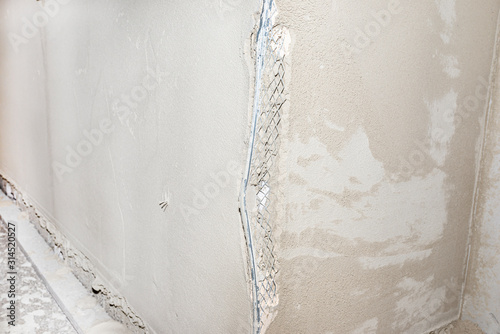 Damaged corners of plastered walls, visible aluminum corner.