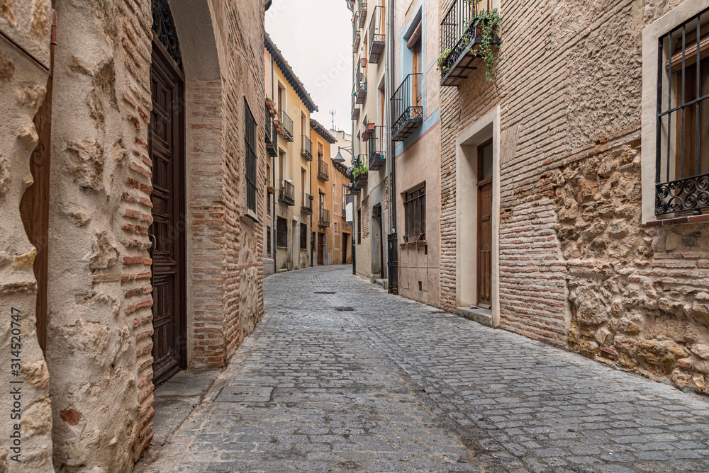 View of a narrow street in the old town of Segovia, Spain. Old style of construction still used in this part of Spain