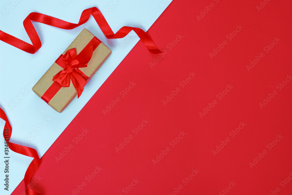 Valentine's day celebration concept. Gift with a red bow on a double white-red background with space for your text.