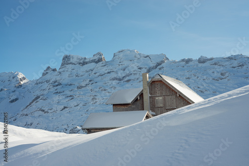 Old house in alpine winter landscape