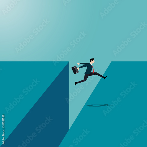 Businessman jumping reach the other side of the cliff