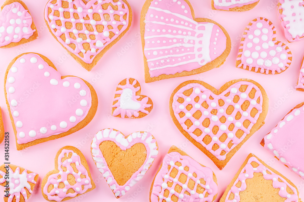 Fototapeta premium Handmade Glazed Decorated Heart Shaped Cookies on Pink Background. Concept of Happy Valentines Day. Top view