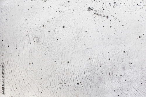 Small circular shaped dirt spread on crack white concrete surface