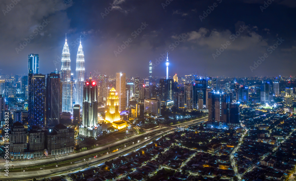 Naklejka premium KUALA LUMPUR / Malezja - 01 STYCZNIA 2020: Widok z góry na centrum miasta Kuala Lumpur z budynkami deweloperskimi, transportem, infrastrukturą energetyczną. Centrum finansowe i biznesowe. logo usunięte