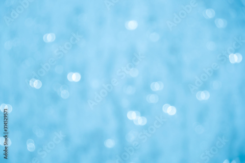 Blurred light blue bubbles bokeh abstract background.