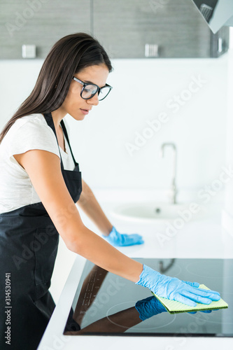 Young woman clean kitchen at home. Clean company.