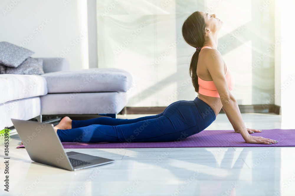 Young pretty woman make yoga exercises at home