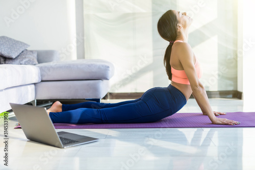 Young pretty woman make yoga exercises at home