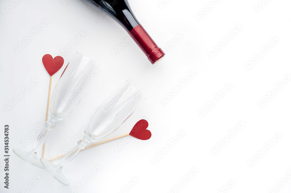 composition for holy day Valentine red wine and glasses, gift and hearts made of paper on a white background with copy space for your text composition for holy day Valentine red wine and glasses, gift and hearts made of paper on a white background with copy space for your text