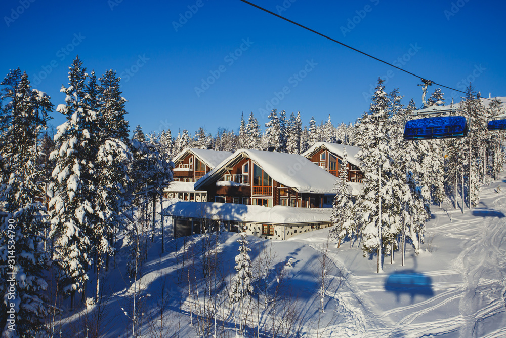Beautiful vibrant aerial winter mountain view of ski resort, sunny winter day with slope, piste and ski lift