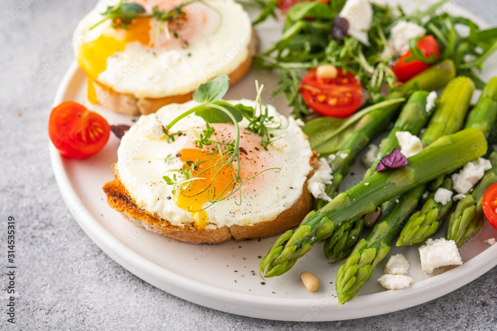 Egg and green asparagus on toast with greens. Healthy breakfast. Egg and green asparagus on toast with greens. Healthy breakfast.