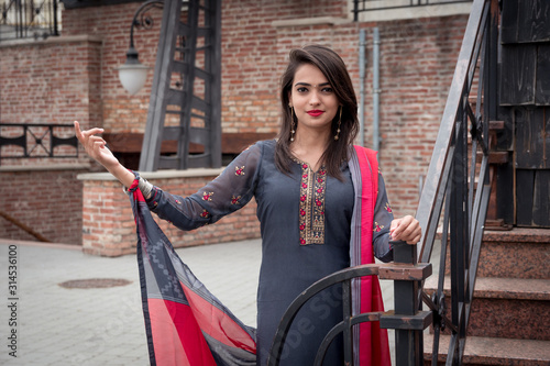 An Indian girl stands on the street of the city. Girl in traditional Indian clothing, salwar kameez.