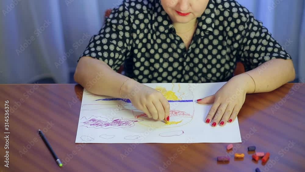 A young artist is working on a drawing using the pastel technique
