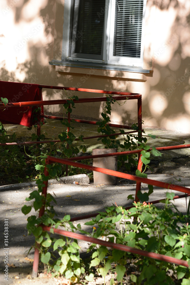 Red fenced entrance to an appartment building with a window Red fenced entrance to an appartment building with a window