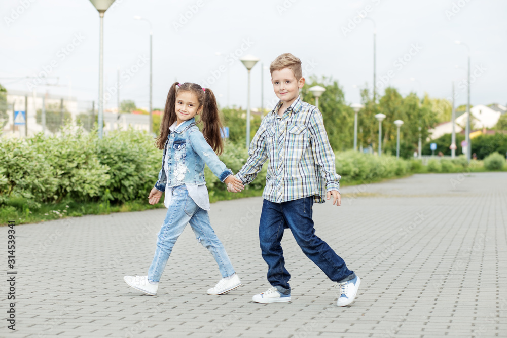 Little friends go hand in hand. The concept of childhood, back to school, friendship.