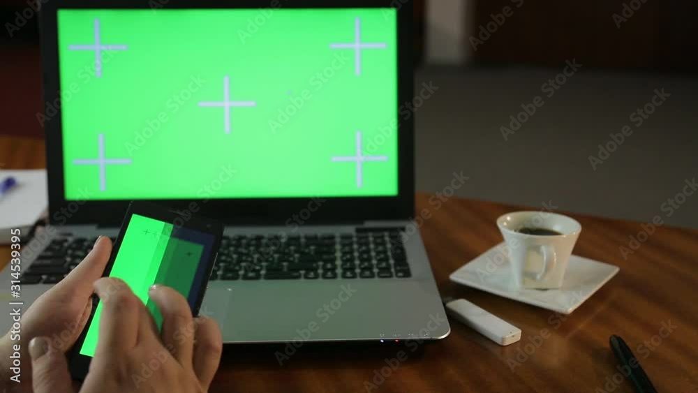 A woman lingered in the office in the evening looking for information in her smartphone for a report and drinking coffee A woman lingered in the office in the evening looking for information in her smartphone for a report and drinking coffee