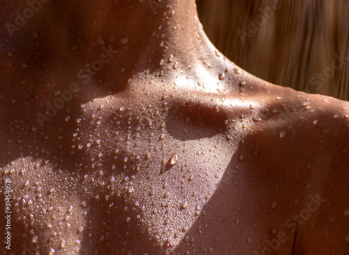 Fototapeta drops of sweat on tanned skin, close-up