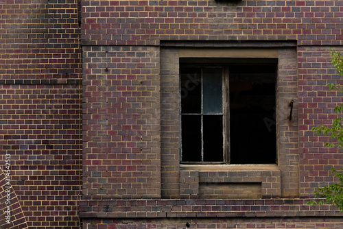 Broken window of an abandoned house, clinker brick facade with broken window, ailing house, lost places