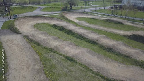 Artificial cycle track for sports cycling. The physical development of youth. Aerial photography from a drone or quadrocopter. Crossed hilly terrain with a dirt road. Obstacle course for sports racers