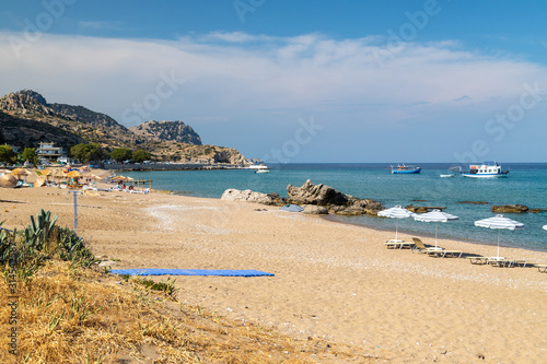 Fototapeta Naklejka Na Ścianę i Meble -  Stegna beach on Greek island Rhodes with sand, sunshades and boats in the background