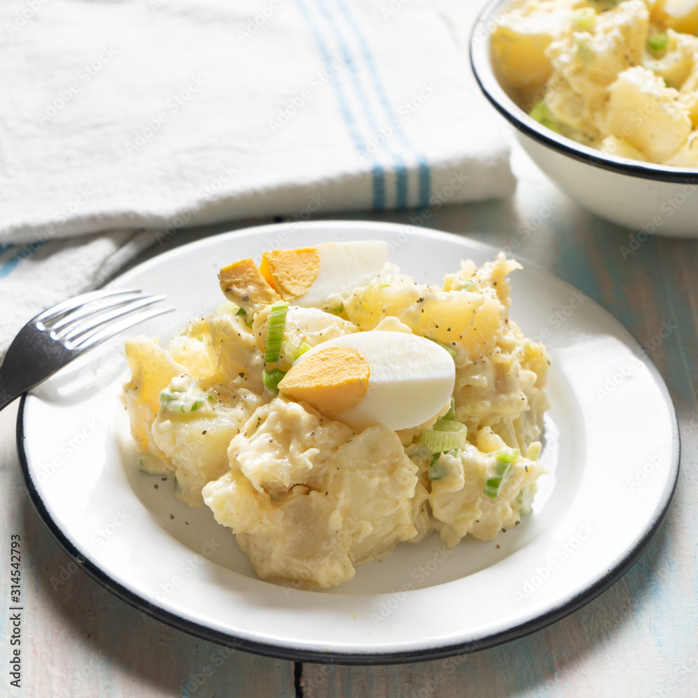 Potato salad with egg and mayonnaise on wooden background Potato salad with egg and mayonnaise on wooden background