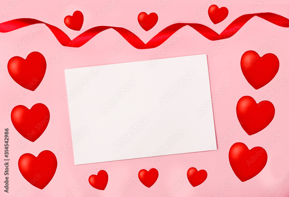White notebook sheet on a pink background near red hearts and a satin ribbon. The concept of St. Valentine's Day, love, Valentine, wish of love. Copy space