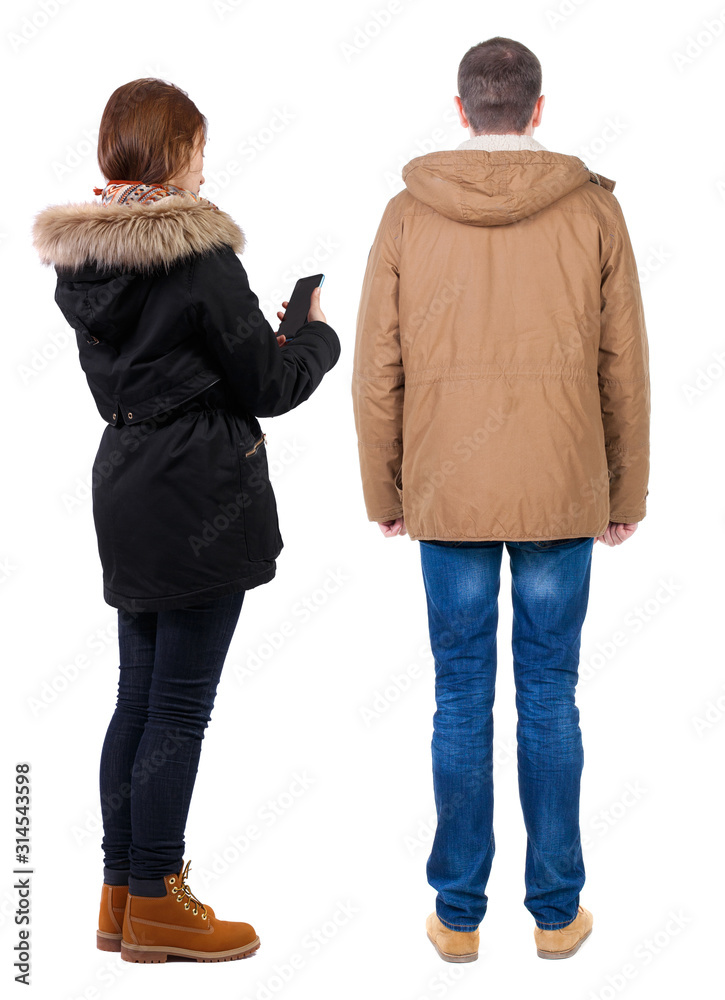 Back view of couple in winter jacket photographed on a mobile phone in winter jacket. Back view of couple in winter jacket photographed on a mobile phone in winter jacket.