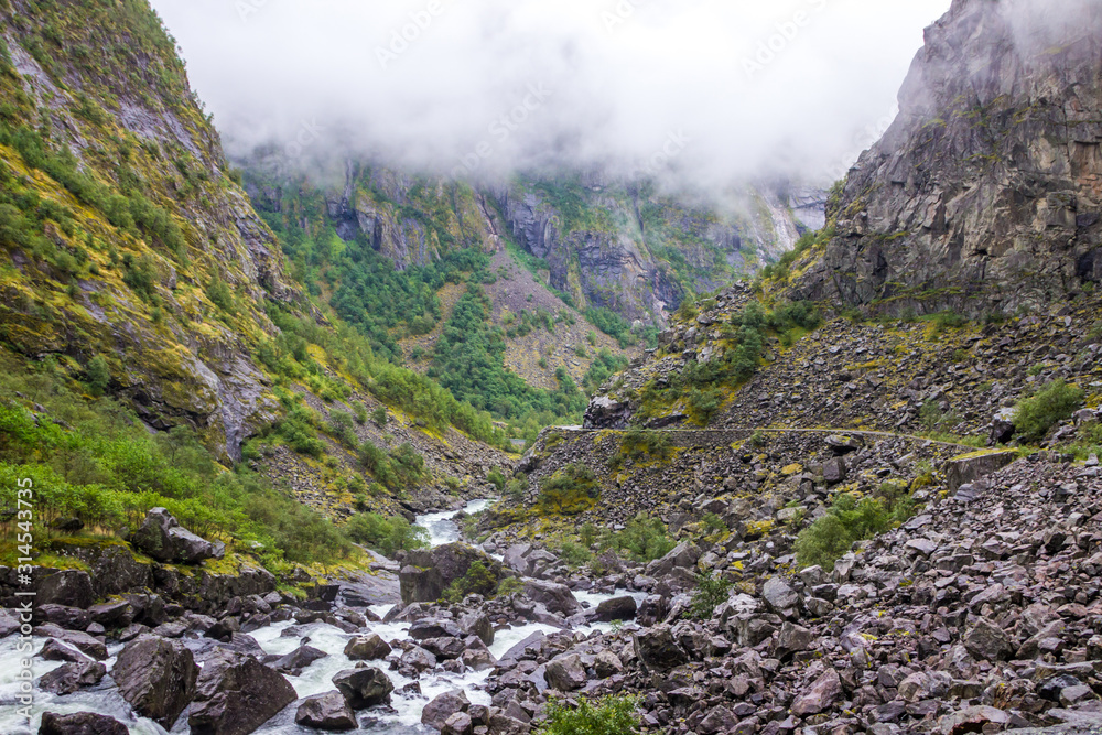 rocks in a rushing mountain river during a rainy day in Norway rocks in a rushing mountain river during a rainy day in Norway