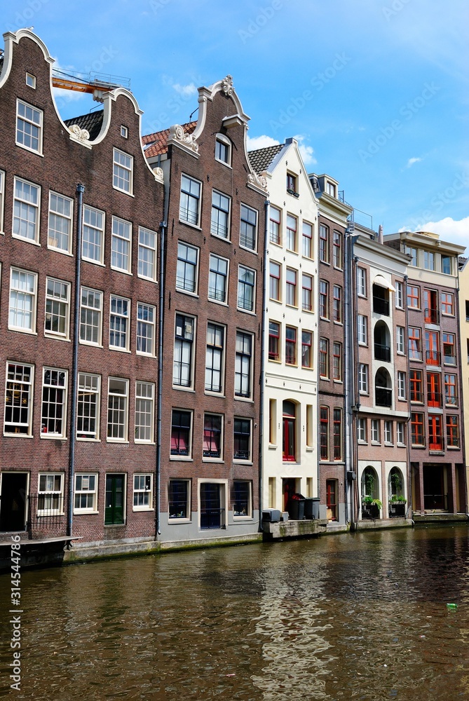 Traditional dutch medieval houses built right on a canal in Amsterdam, Netherlands