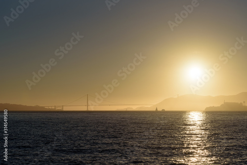 Sunset over Alcatraz island in San Francisco bay area, with Golden Gate bridge in background