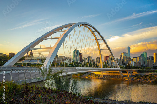 Edmonton, Alberta, Canada skyline at dusk with suspension bridge in foreground and clouds
