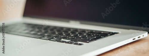 New Apple Macbook Pro on the wooden close up background banner.