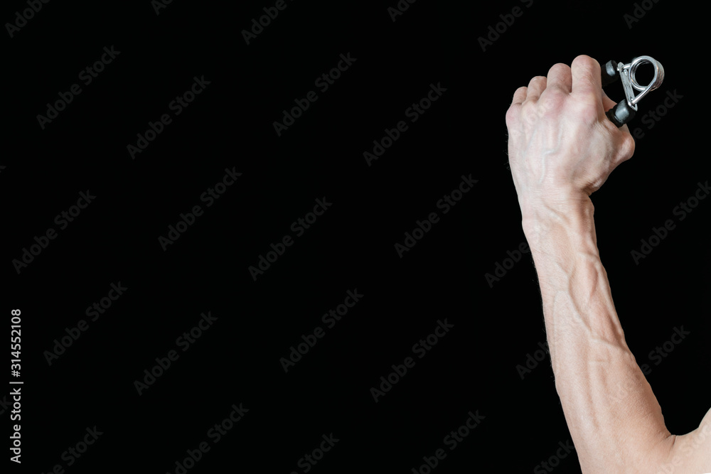 Fototapeta premium A man's hand holds an expander