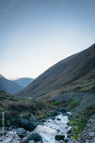 Juta village landscape with river and mountains at sunset - a popular trekking site in the Caucasus mountains, Kazbegi region, Georgia.