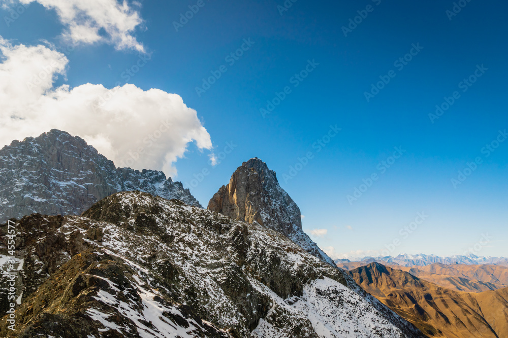 dramatic snowy mountain landscape in Juta trekking area landscape  in sunny autumn day -  popular trekking  in the Caucasus mountains, Kazbegi region, Georgia.