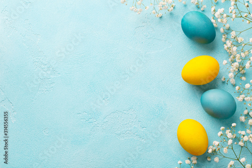 Canvas Print Colorful Easter eggs with flowers on blue background