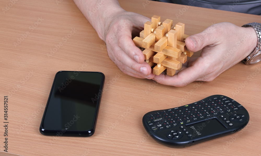 Obraz premium Person chooses a wooden puzzle instead of electronic devices