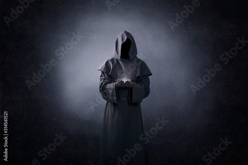 Fototapet Ghostly figure with light in hands in the dark