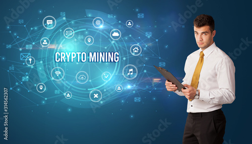 Businessman thinking in front of technology related icons and CRYPTO MINING inscription, modern technology concept
