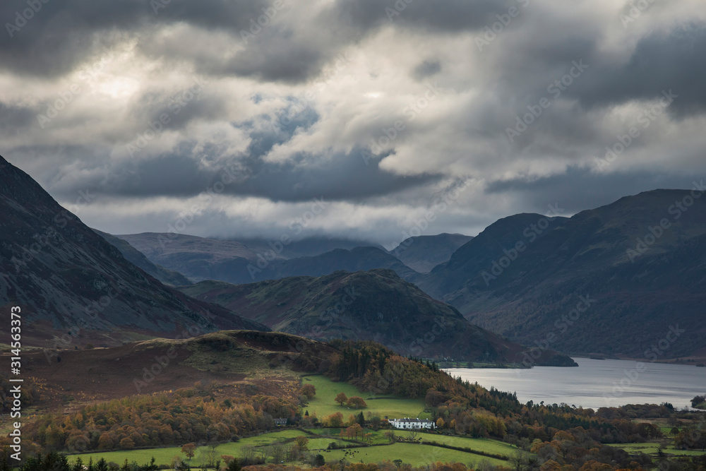 Majestic sun beams light up Crummock Water in epic Autumn Fall landscape image with Mellbreak and Grasmoor