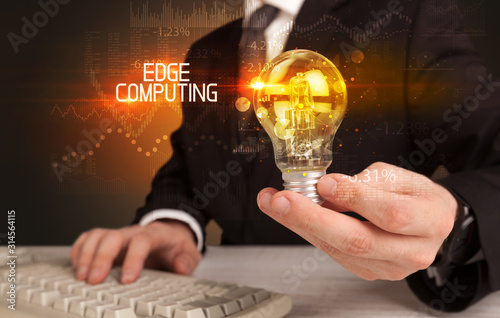 Businessman holding lightbulb with EDGE COMPUTING inscription, Business technology concept