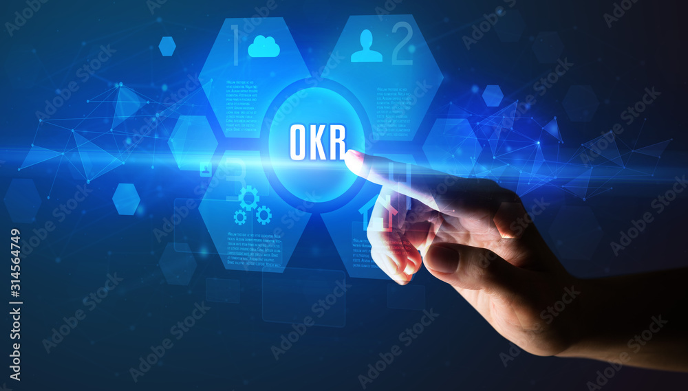 Hand touching OKR inscription, new technology concept Hand touching OKR inscription, new technology concept