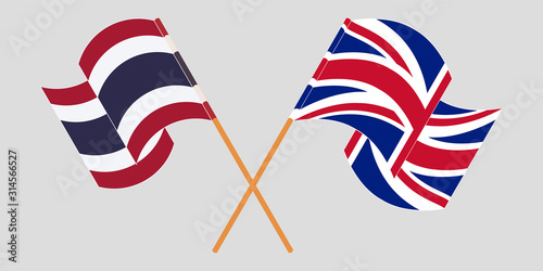 Crossed and waving flags of Thailand and the UK